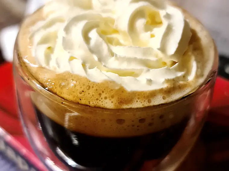 Café irlandés en copa de vidrio, con crema encima