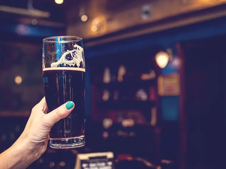 Una mano sostiene un vaso de cerveza