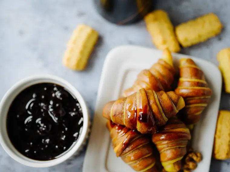 Café, croissants y mermelada en una mesa a la hora del desayuno